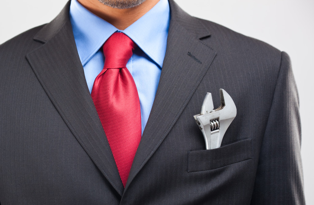 Businessman keeping an adjustable wrench in his pocket